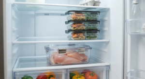 5 Rules in Every Safe Meal Prep Storage Guide 3 Refrigerator shelves organized with raw meat stored below prepped meals to prevent cross contamination